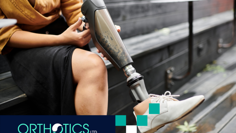 An amputee is holding his prosthetic leg