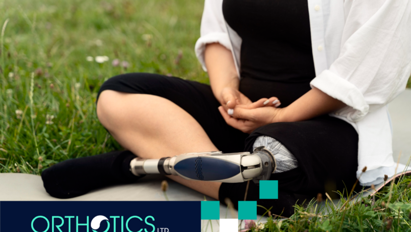 An amputee with a prosthetic leg sitting on the grass