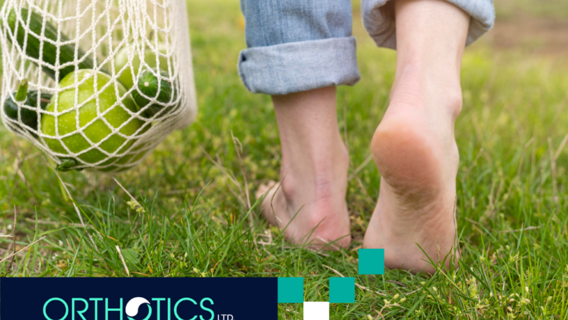 A person walking on the grass barefoot