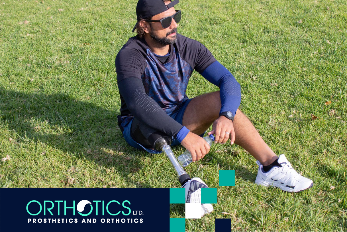 An amputee wearing prosthesis sitting on the grass