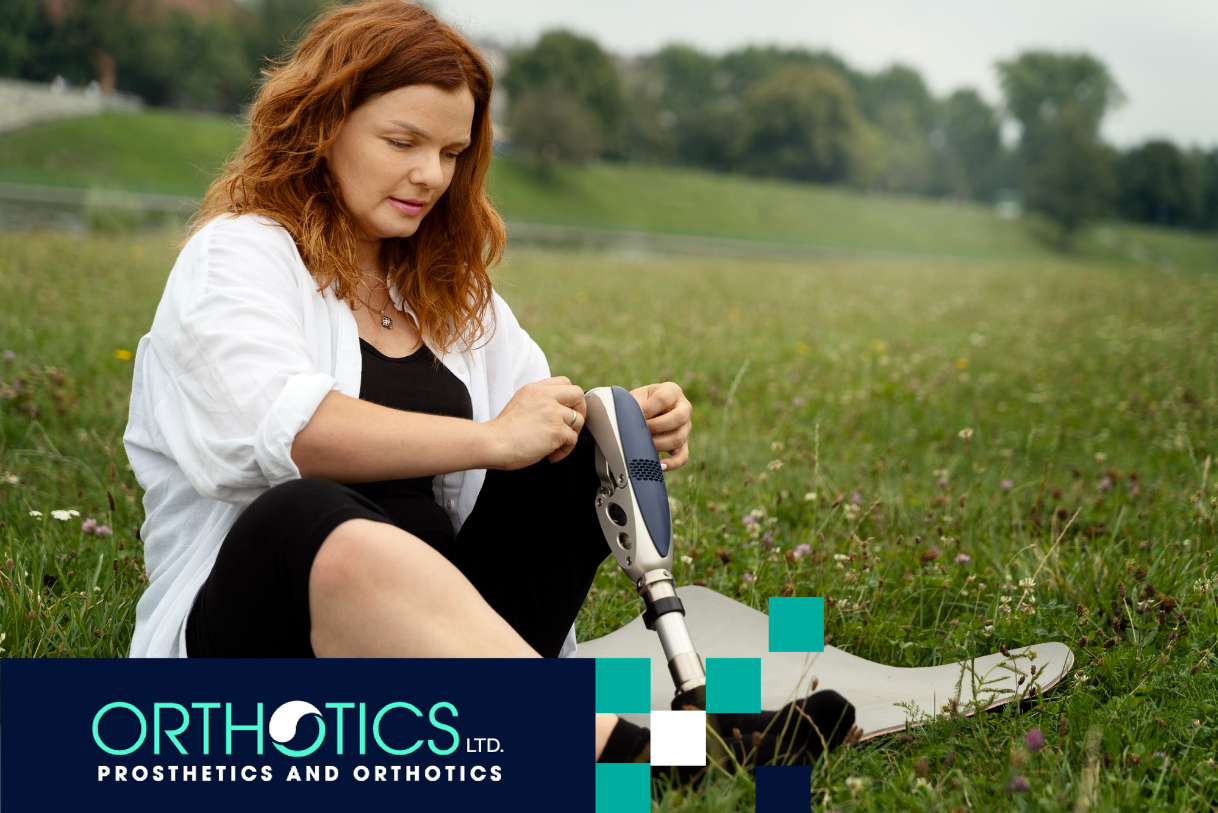 A woman wearing a prosthetic sitting on grass