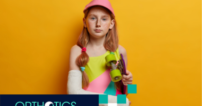 A kid wearing prosthetic holding a skateboard