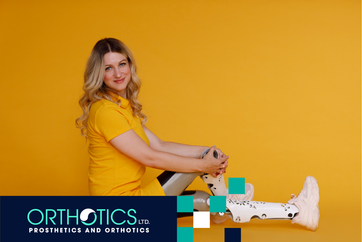 A girl wearing prosthetic cosmetic cover sitting on a floor in front of a yellow backdrop