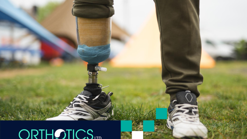 An amputee wearing a prosthetic leg standing on the grass
