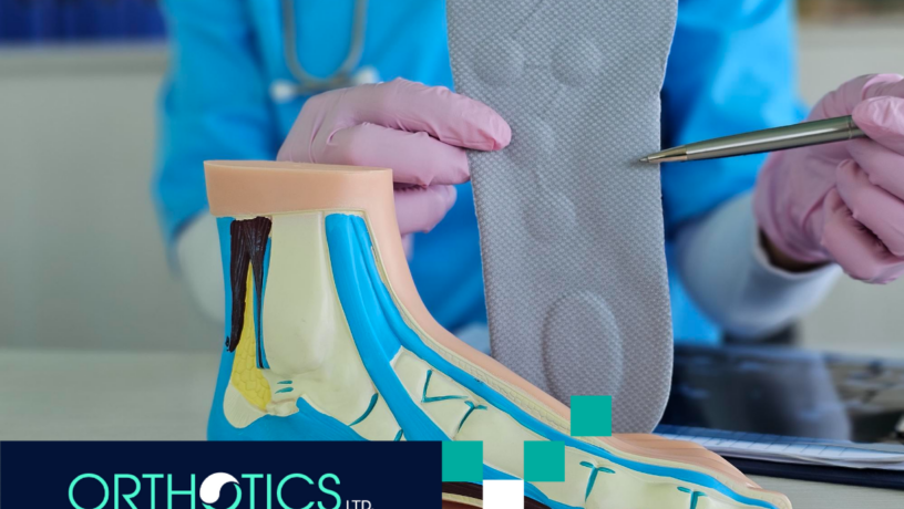 A medical assistant holding an orthotic insole, with a model of a foot on a table