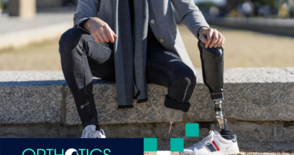 An amputee sitting outdoors, holding a prosthesis