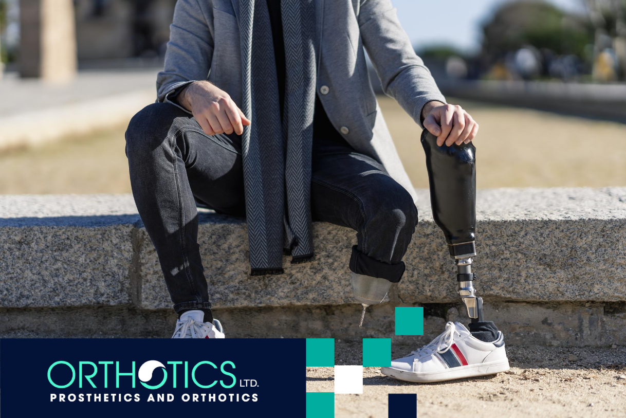 An amputee sitting outdoors, holding a prosthesis