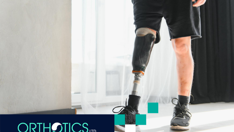 An amputee wearing prosthetic standing by a window