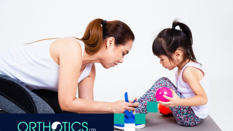 A child getting her orthotic checked by her mother