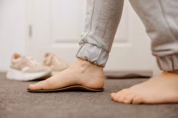 A flat foot stepping on a custom orthotic shoe insole