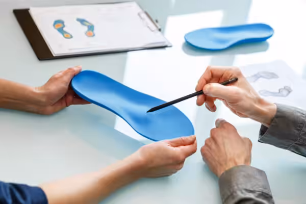 Two persons holding and talking about orthotics for flat feet