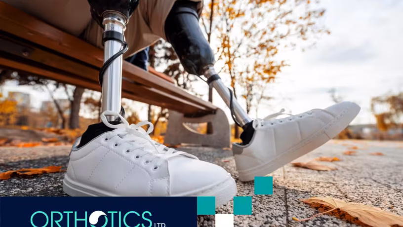 A man wearing prosthetics sitting on a bench during fall season