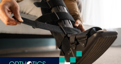 Man taking off an ankle-foot orthosis on his leg, sitting on a sofa at home