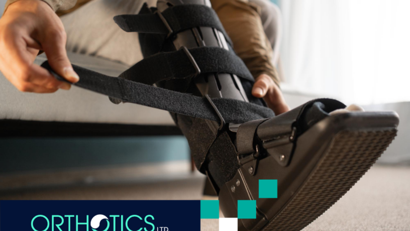 Man taking off an ankle-foot orthosis on his leg, sitting on a sofa at home